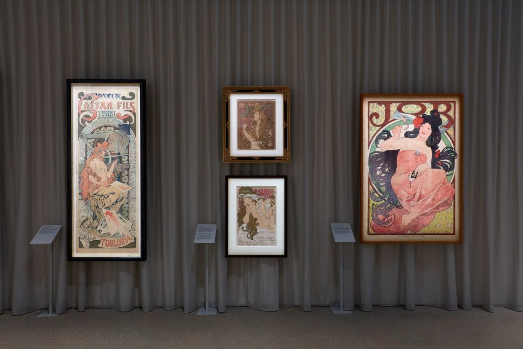 installation view of an exhibition of paintings on the walls.