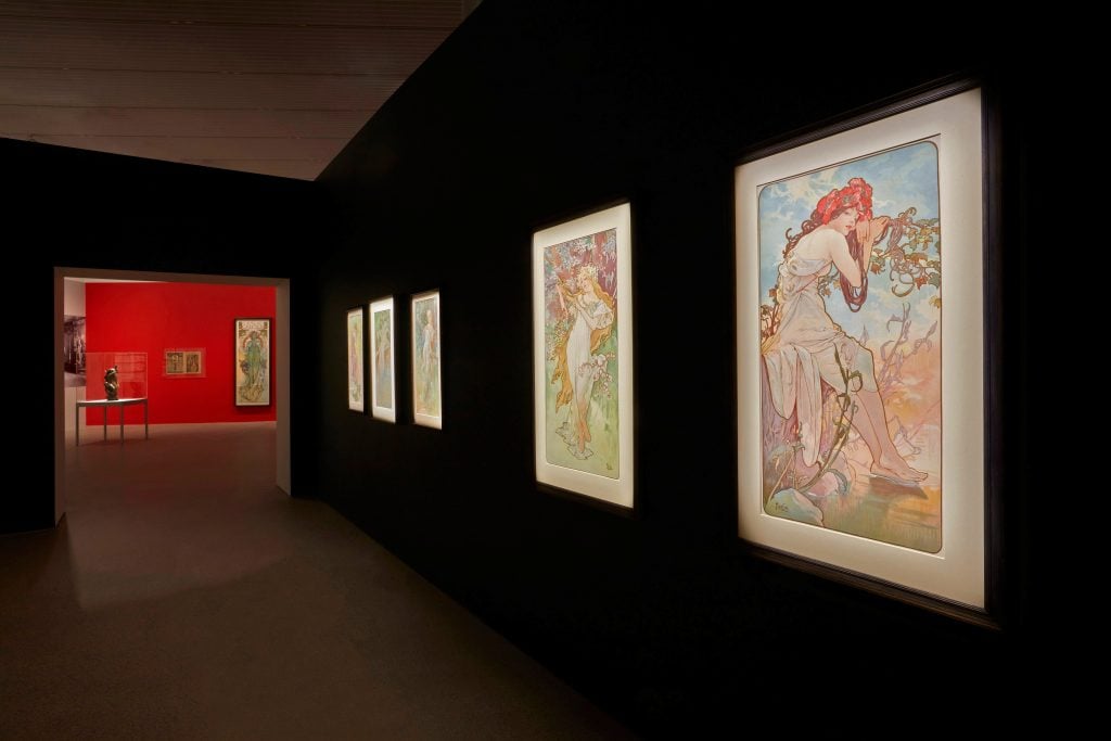 installation view of an exhibition of paintings on the walls.