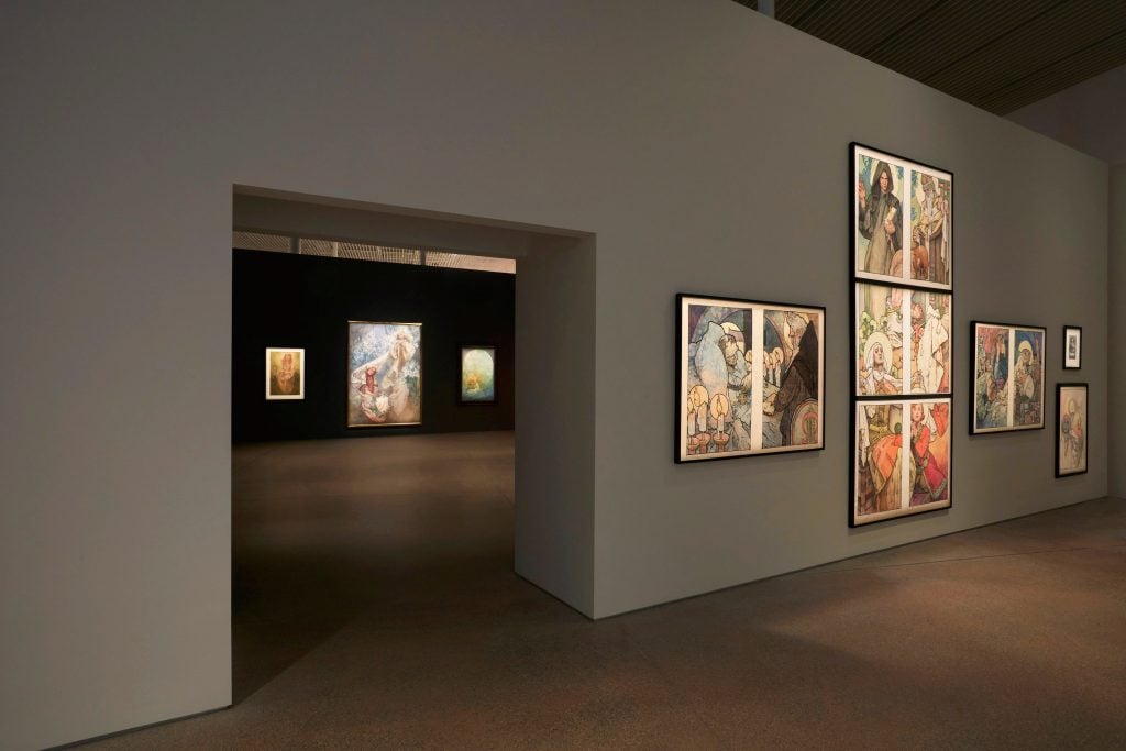 installation view of an exhibition of paintings on the walls.