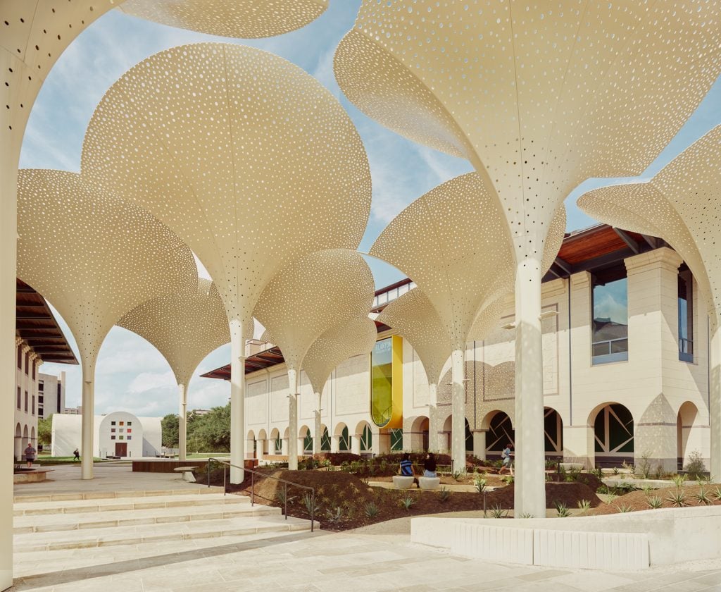 an image of the white arches of the Blanton Museum with Ellsworth Kelly chapel in the background