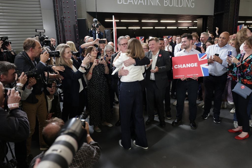 two people kiss in a crowd of people