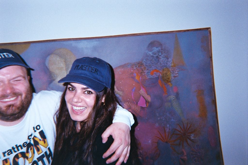 woman and man smiling wearing caps with plaster phrase