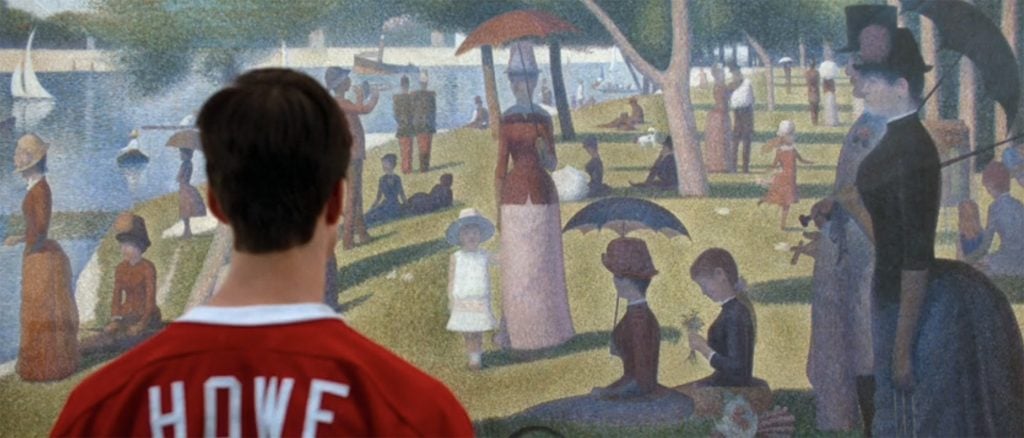 A man standing in front of Seurat's pointillist painting La Grande Jatte.