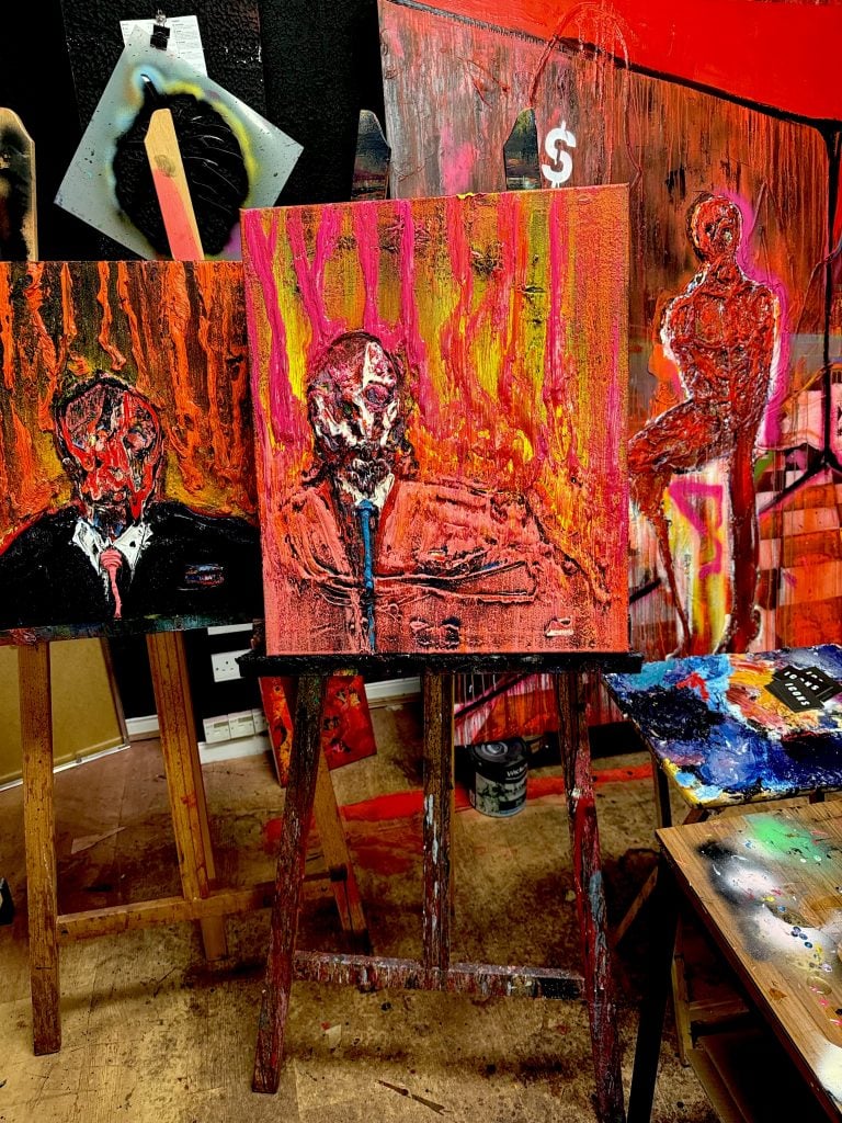 A grouping of semi-abstract paintings by Lincoln Townley on easels in a studio space.